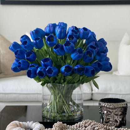 Arrangement de tulipes bleues dans grand vase cylindrique